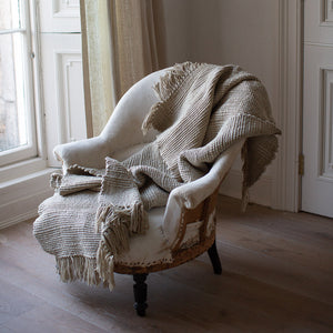 
            
                Load image into Gallery viewer, TEXTURED AND TASSELED HANDWOVEN MERINO WOOL BLANKET IN NATURAL
            
        