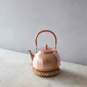 Japanese copper kettle on straw trivet